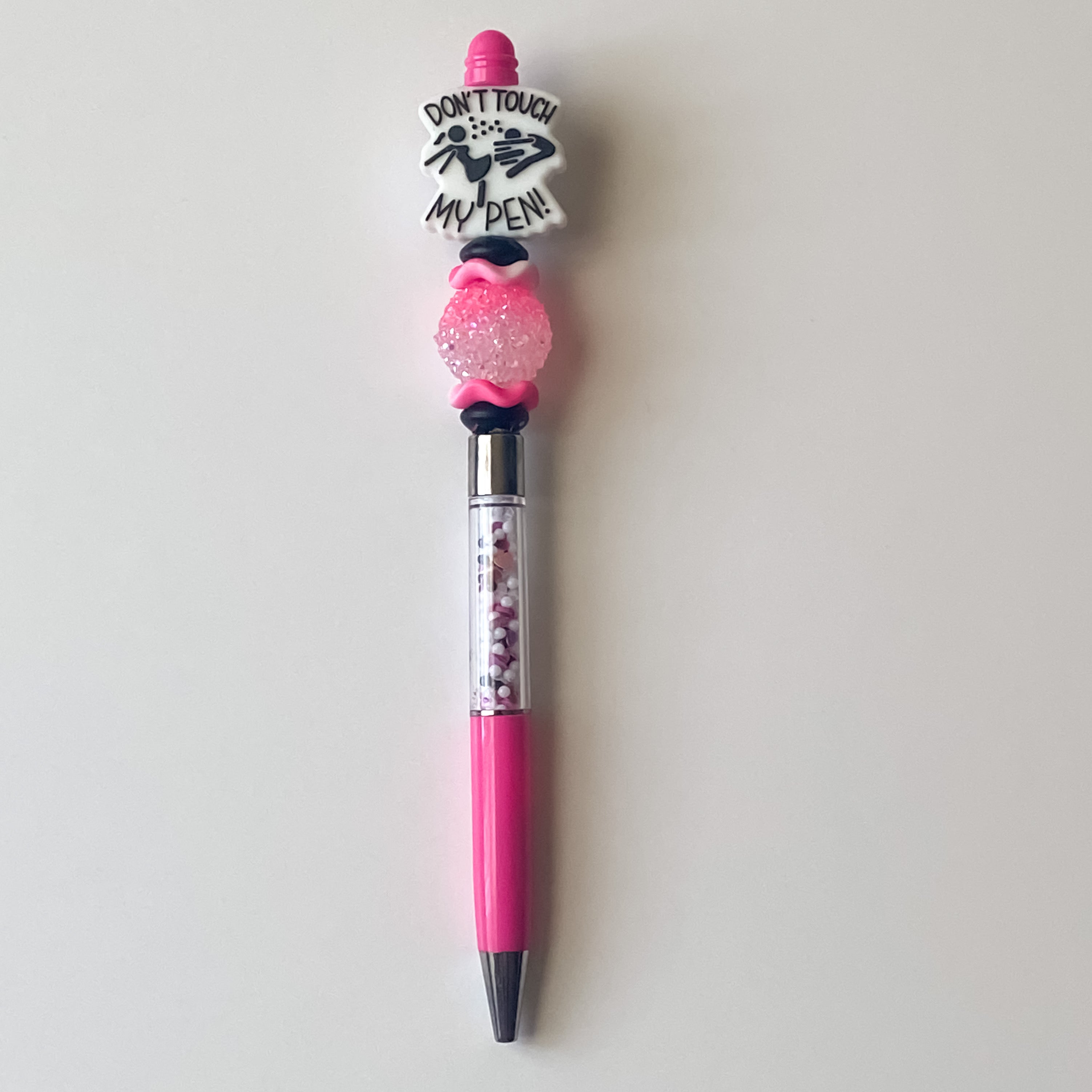 Handmade pink and white beaded pen featuring a Don’t Touch My Pen focal bead and sparkling accent bead.
