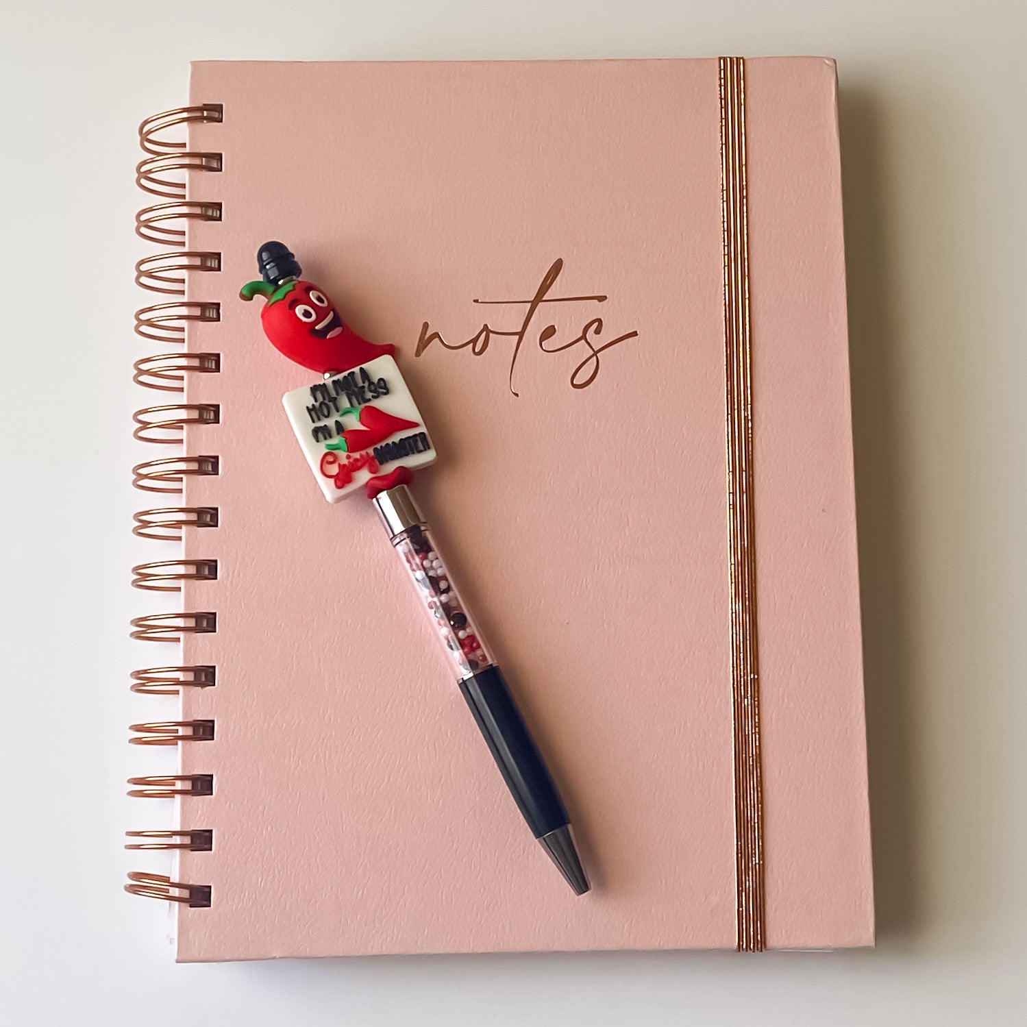Handmade novelty pen with smiling red chili pepper topper and Spicy Disaster focal bead on a refillable black ink pen