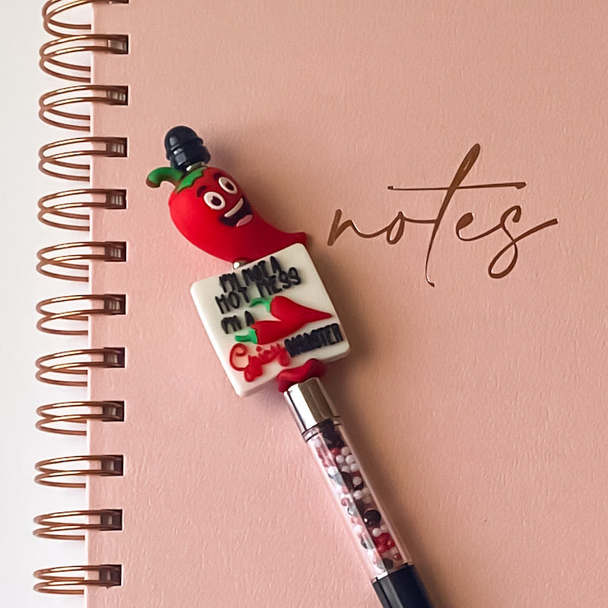 Handmade novelty pen with smiling red chili pepper topper and Spicy Disaster focal bead on a refillable black ink pen