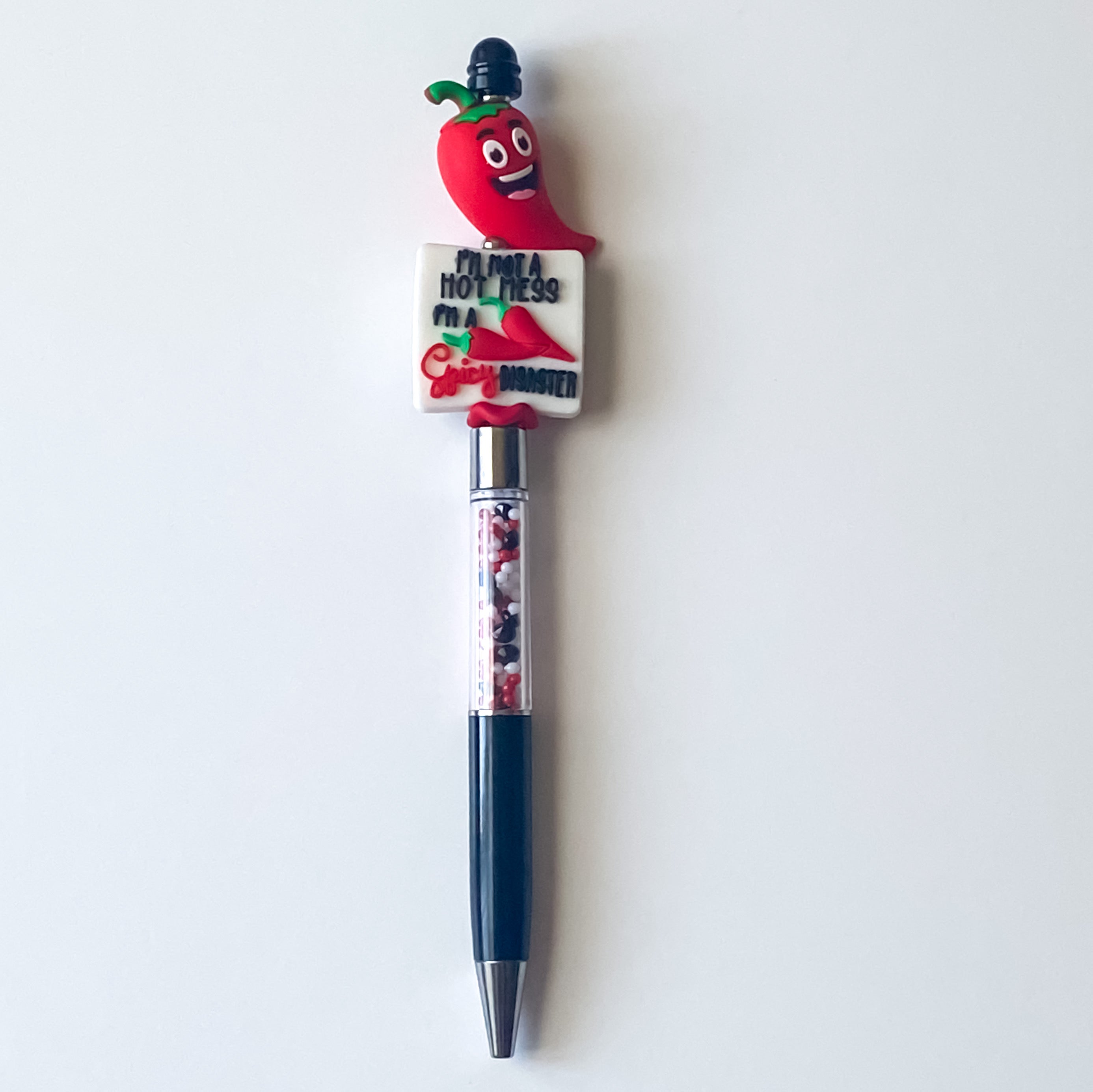 Handmade novelty pen with smiling red chili pepper topper and Spicy Disaster focal bead on a refillable black ink pen